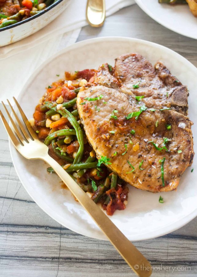 Braised Pork Chops and Garden Vegetables (Chuletas a la Jardinera) | Braised pork chops in a tomato sauce with fresh carrots, corn, & green beans. Resulting in tender pork chops in a sweet and savory sauce & crisp vegetables. | The Noshery