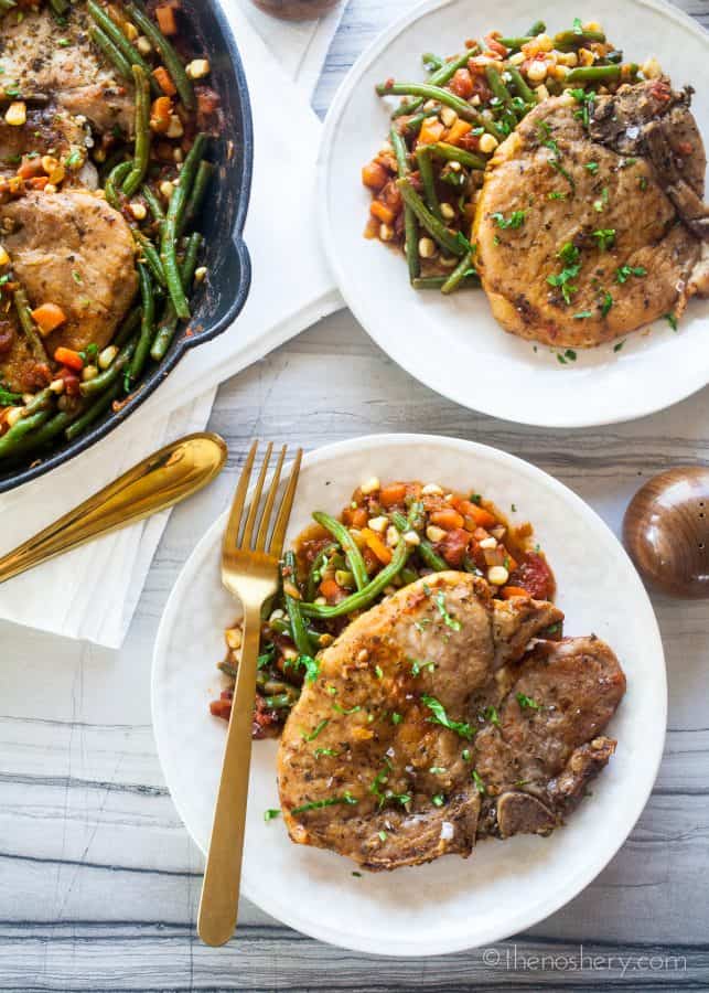 Braised Pork Chops and Garden Vegetables (Chuletas a la Jardinera) | Braised pork chops in a tomato sauce with fresh carrots, corn, & green beans. Resulting in tender pork chops in a sweet and savory sauce & crisp vegetables. | The Noshery