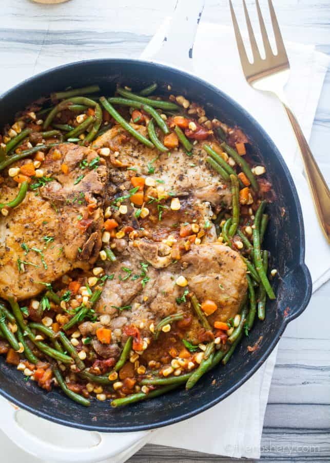 Braised Pork Chops and Garden Vegetables (Chuletas a la Jardinera) | Braised pork chops in a tomato sauce with fresh carrots, corn, & green beans. Resulting in tender pork chops in a sweet and savory sauce & crisp vegetables. | The Noshery