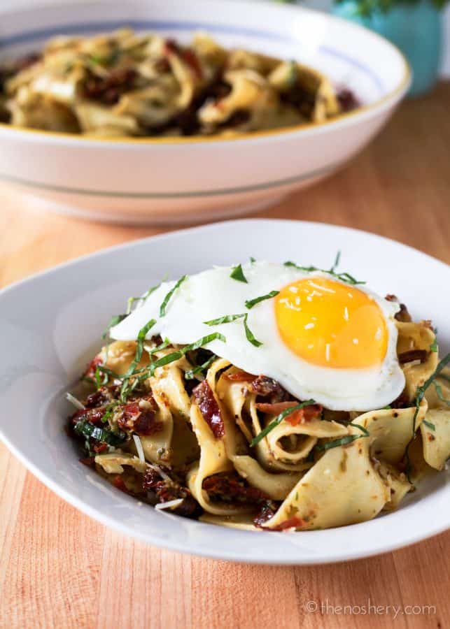 Broad pappardelle pasta noodles toss in a briny and salty olive tapenade with sweet sun-dried tomatoes and crispy prosciutto. Topped with a runny fried egg.