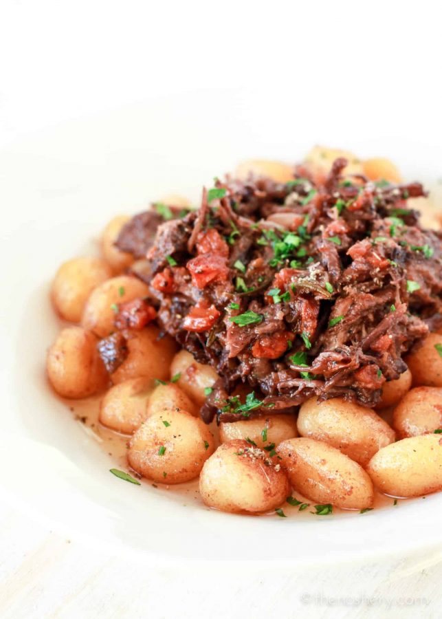 Braised Beef in Red Wine pilled over pan fried gnocchi potato dumplings. | The Noshery