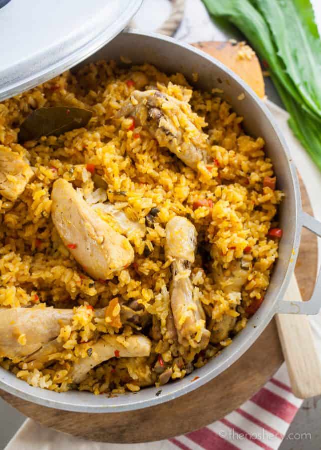 Arroz con Pollo - Overhead shot of chicken and yellow rice in a large pot.