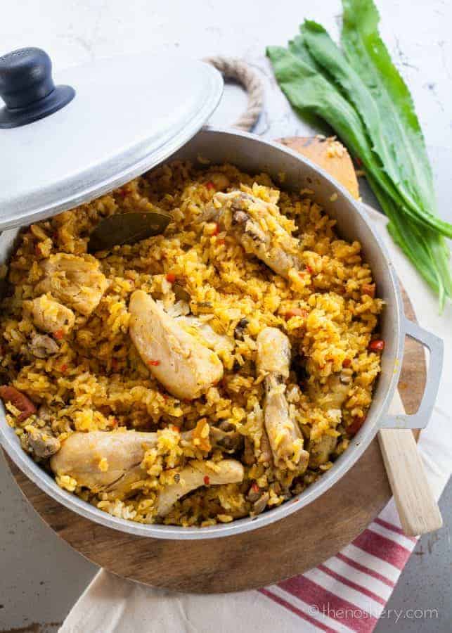 Arroz con Pollo (Chicken and Rice) - Overhead view of chicken and yellow rice in a large pot. 