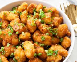 Orange Chicken That's Better Than Takeout | Orange chicken with a light crispy breading & a sweet and tangy sauce. There is no lack of orange flavor, & the red pepper flakes give it a touch of heat. | The Noshery