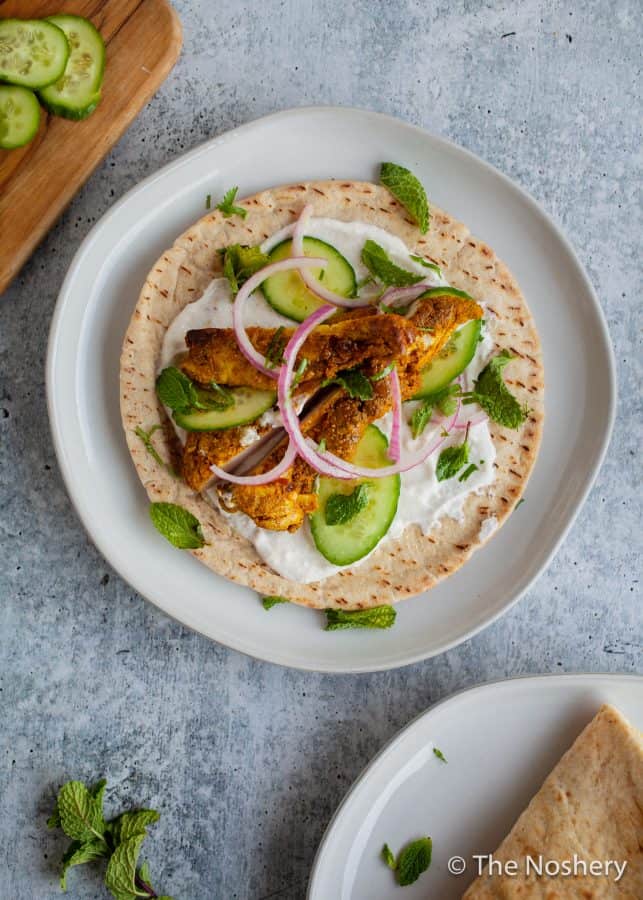 Chicken Shawarma Wraps | These chicken pitas are an adaptation of the popular middle eastern street food shawarma. The chicken tenderloins are rubbed with shawarma spices and served in a warm pita with tangy yogurt. This flavor bomb is a perfect weeknight meal | The Noshery