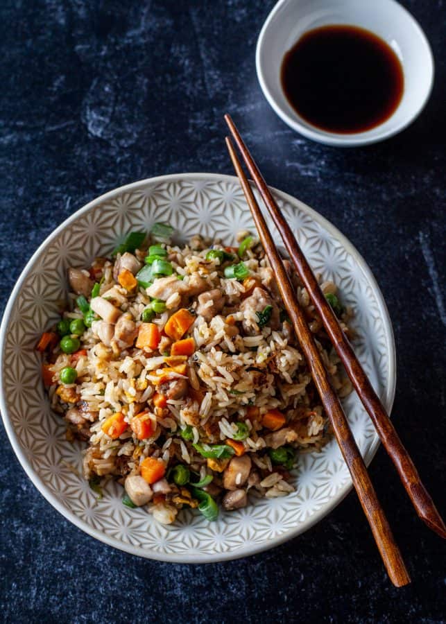 Overhead shot of chicken fried rice with chopsticks resting on bowl| The Noshery