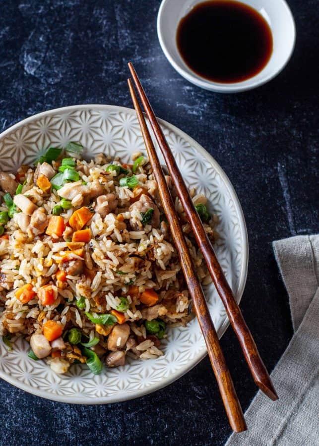 Overhead shot of chicken fried rice with chopsticks resting on bowl| The Noshery