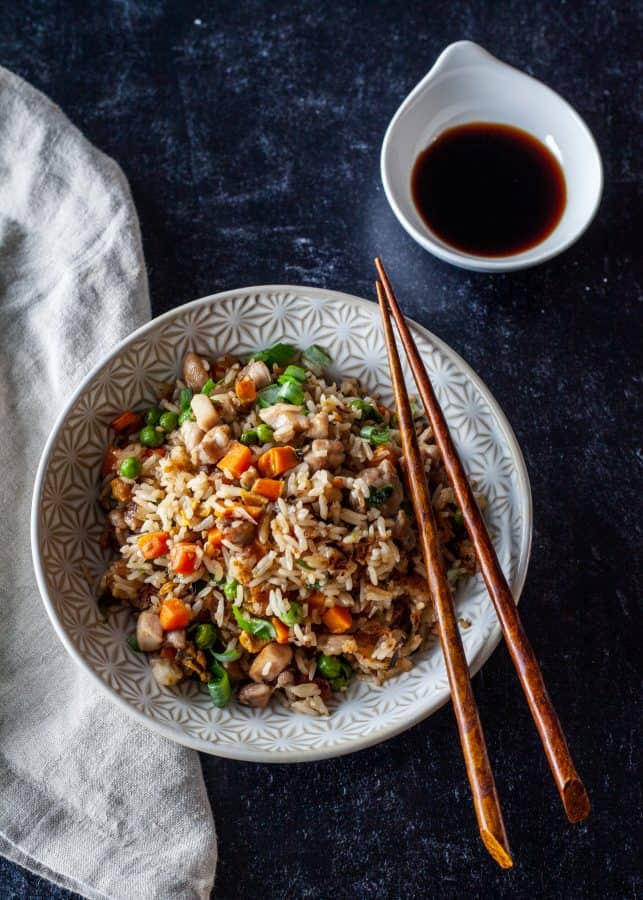 Overhead shot of chicken fried rice with chopsticks resting on bowl| The Noshery